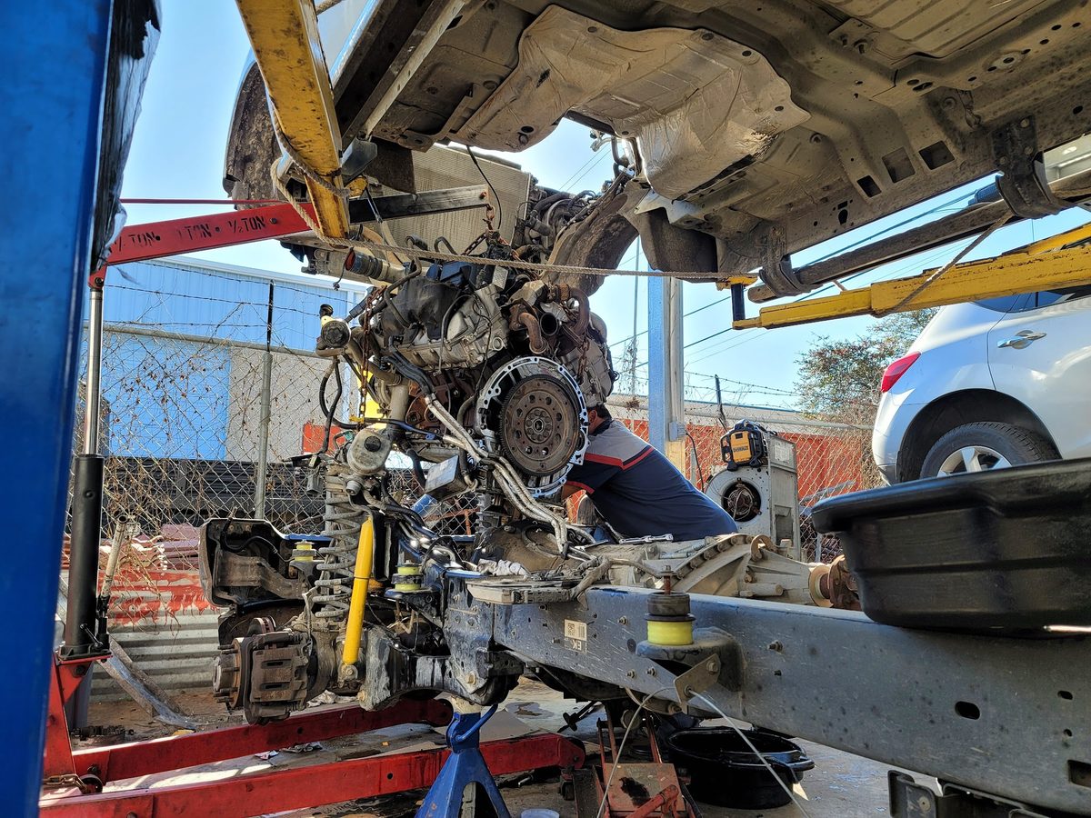 A customer's car up on the lift mid-repair in the bay